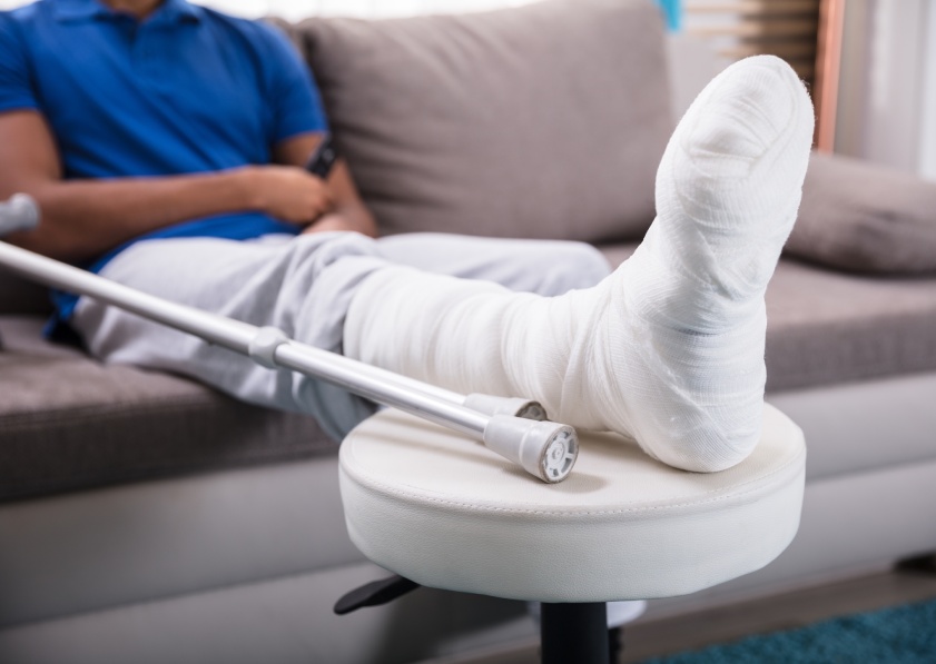 Close-up Of A Man's Broken Leg And Crutches