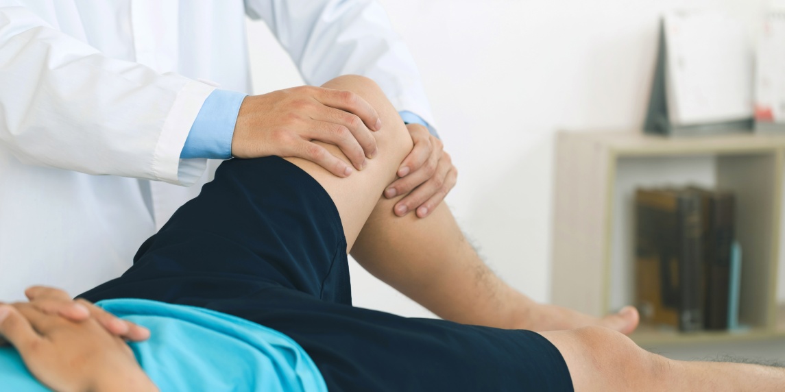 physiotherapist massaging the knee of a patient. rehabilitation and recovery after physical knee injuries.Rehabilitation physiotherapy. Sportsman Recovering from Injury, Undergoing Rehabilitation.